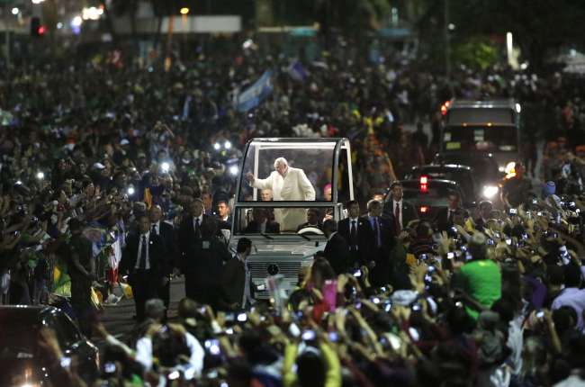 Pope Francis waves to people from his popemobile as he arrives for a vigil with pilgrims in Rio de Janeiro, Brazil, Saturday.   AP-Yonhap News