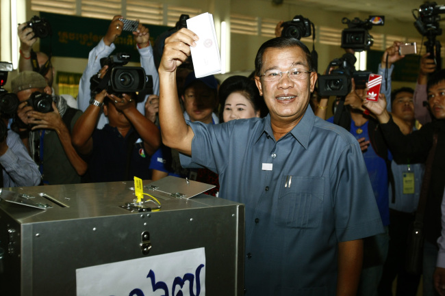 Cambodia’s Prime Minister Hun Sen shows his ballot at a polling station in Takhmau town, south of Phnom Penh, Sunday.   AP-Yonhap News