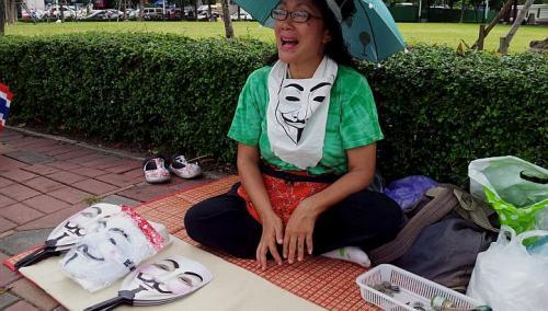 Street vendor China Akaradech sells Guy Fawkes fans at a “white mask” rally at Lumpini Park in Bangkok earlier this month.   The Straits Times