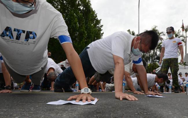 Protesters do push-ups during an anti-military rally outside the Defense Ministry in Taipei.   AFP-Yonhap