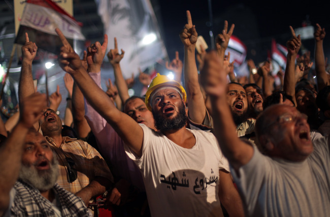 Supporters of Egypt‘s ousted President Mohammed Morsi chant slogans during a protest outside Rabaah al-Adawiya mosque, where they have installed a camp and hold daily rallies, at Nasr City, in Cairo, Wednesday.   AP-Yonhap News