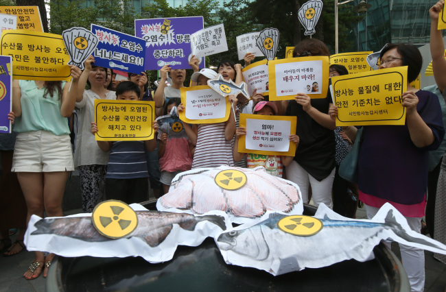 Environmental and civic groups hold a rally in Seoul on Thursday against Japanese fisheries imports. (Yonhap News)