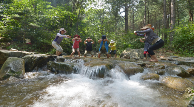 산음 자연휴양림<br />김명섭 기자 msiron@heraldcorp.com
Participants engage in a “gi,” or energy, exercise with their feet in the stream as part of a forest therapy program.   Kim Myung-sub/The Korea Herald