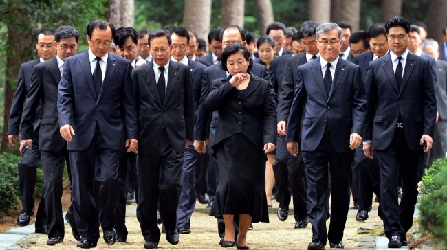 Hyundai Group chairwoman Hyun Jeong-eun (center) and executives walk out of a graveyard after paying their respects at the tomb of her late husband and the former group chairman Chung Mong-hun in Hanam, Gyeonggi Province, Friday.   Kim Myung-sub/The Korea Herald
