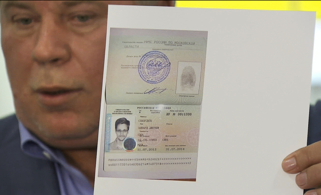 Russian lawyer Anatoly Kucherena shows a temporary document to allow Edward Snowden to cross the border into Russia while speaking to the media after visiting Snowden at Sheremetyevo airport outside Moscow on Thursday.   AP-Yonhap News