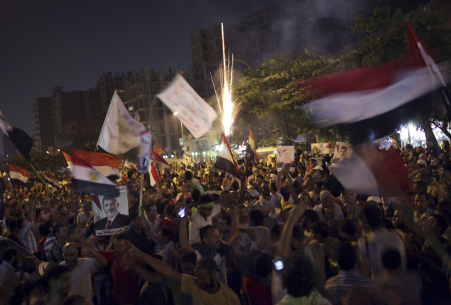 Supporters of Egypt’s ousted President Mohammed Morsi wave national flags during a protest near Cairo airport in Cairo on Friday.   AP-Yonhap News