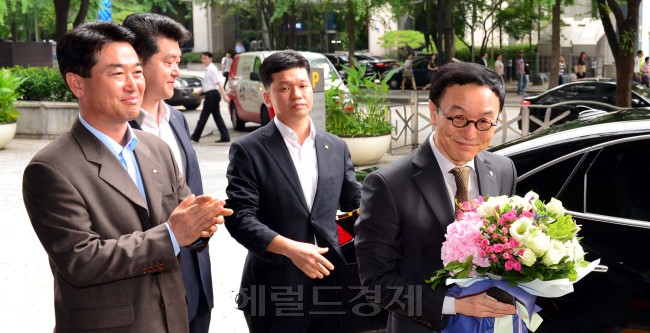 15일 만에 정상 출근한 이건호 KB국민은행장이 5일 서울 여의도 국민은행 본점 앞에서 직원이 전달한 꽃다발을 들고 집무실로 들어가고 있다. 김명섭 기자/msiron@heraldcorp.com
