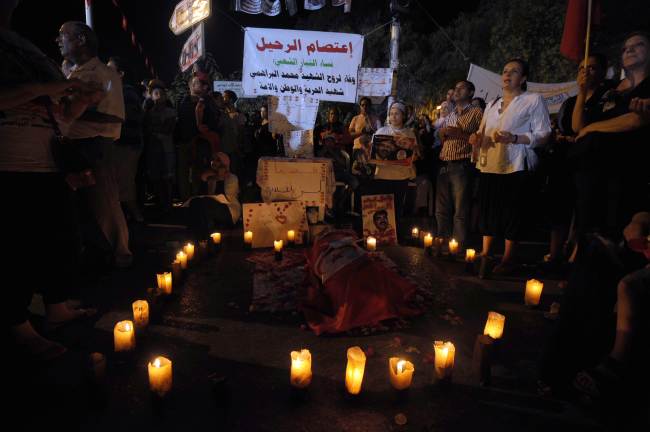 <YONHAP PHOTO-0406> Tunisian protesters light candles by a symbolic coffin on August 4, 2013 in Tunis in front of the Constituent Assembly headquarters against Tunisia's Islamist government in Tunis. Tunisia said its forces killed a "terror" suspect in a dawn raid Sunday and separately foiled a political assassination like the one that has plunged the country into crisis. The announcements came after rival protests for and against the Islamist-led coalition government, with the opposition demanding the resignation of the cabinet and the dissolution of the National Constituent Assembly. AFP PHOTO / FETHI BELAID../2013-08-05 10:04:59/ <저작권자 ⓒ 1980-2013 ㈜연합뉴스. 무단 전재 재배포 금지.>
Tunisian protesters light candles by a symbolic coffin in front of the Constituent Assembly headquarters against Tunisia’s Islamist government in Tunis on Sunday.   AFP-Yonhap News