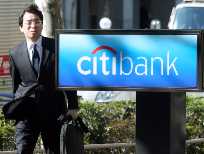 A businessman walks past a Citibank Japan Ltd. branch in Tokyo.    Bloomberg