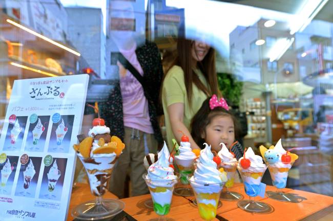 Visitors look at food samples made of plastic at a plastic food maker’s shop in Tokyo on May 28.   AFP-Yonhap News