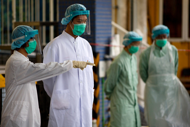 Officials with the Food and Environmental Hygiene Department stand at the Man Kam To control point at the border crossing between mainland China and Hong Kong during live poultry sampling.   Bloomberg