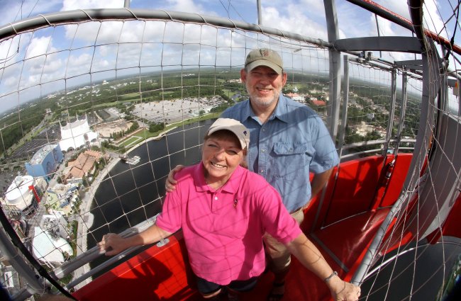 Julie and Mike Neal, producers of the travel guide “The Complete Guide to Walt Disney World,” ride the Characters in Flight helium balloon over Downtown Disney on July 31.   Orlando Sentinel/MCT