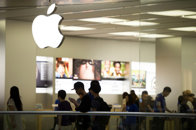 A man looks at his iPhone at an Apple store in Hong Kong.  Bloomberg