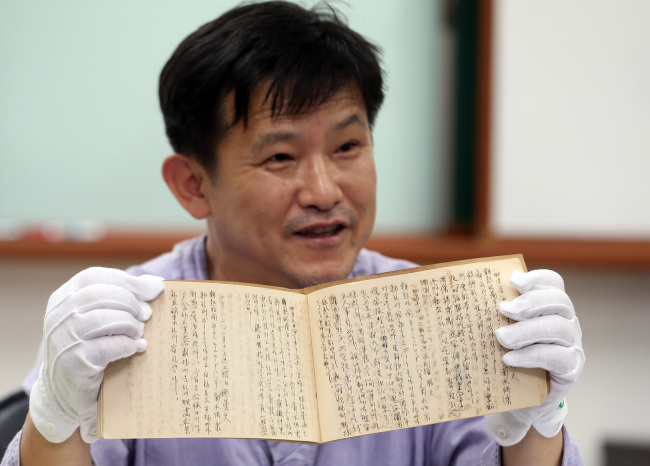 Park Han-yong, a professor at Korea University’s Center for Korean History, shows a diary which a Korean manager of Japanese brothels wrote while staying in Myanmar and Singapore between August 1942 and December 1944 during a press conference Thursday.   Yonhap News