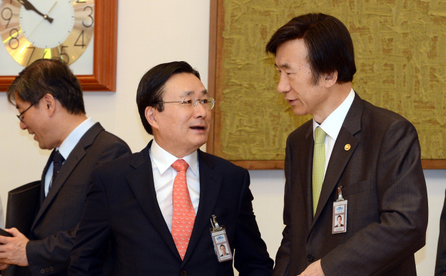 Foreign Minister Yun Byung-se (right) talks to Ju Chul-ki, senior presidential secretary for foreign affairs and security, at Cheong Wa Dae Thursday before new foreign ambassadors present their credentials to President Park Geun-hye.   Chung Hee-cho/The Korea Herald