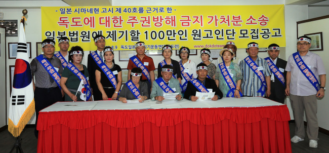 Activists hold a news conference in Sokcho, Gangwon Province, Thursday to announce plans to seek a court injunction with a Japanese court in February to stop Tokyo’s territorial claim to Dokdo.   Yonhap News