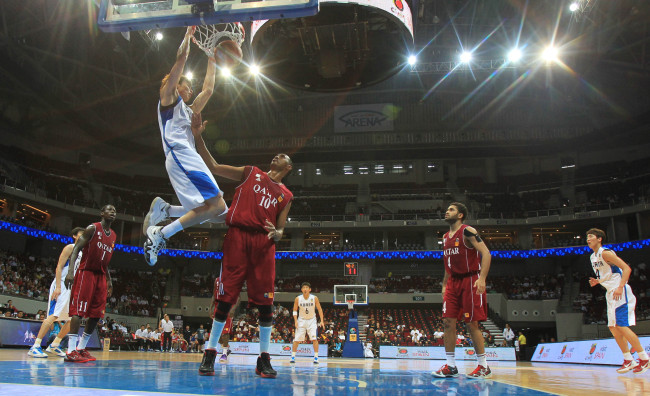 South Korea's Kim Jong-kyu dunks the basketball over Qatari defenders during the quarterfinals of Asian men's basketball championship against Qatar in the Philippines. South Korea won 79-52. (Yonhap News)