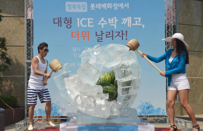 Lotte Department Store on Sunday invited customers to help break the ice surrounding watermelons. They then shared the fruit afterward to help chase the heat ahead of the last hottest day of the year that falls on Monday.   Chung Hee-cho/ The Korea Herald