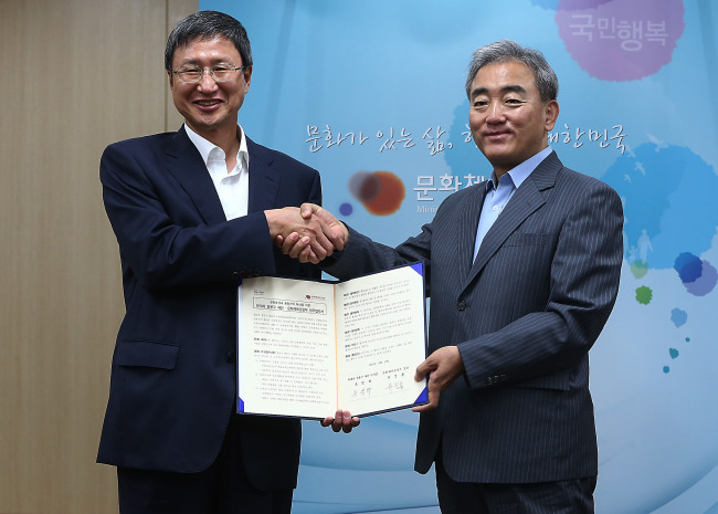 Culture, Sports and Tourism Minister Yoo Jin-ryong (right) shakes hands with Chung Mong-koo Foundation chairman Yoo Young-hak at the ministry in Seoul on Monday after agreeing to cooperate for cultural prosperity.   Yonhap News