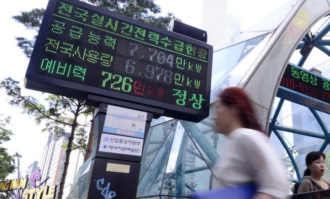 South Koreans pass an electronic display in Gangnam-gu, southern Seoul that shows the nationwide power reserves. (Park Hae-mook/The Korea Herald)