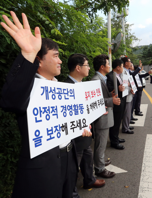 <YONHAP PHOTO-0313> '개성공단 문제 해결 부탁합니다!' (서울=연합뉴스) 홍해인 기자 = 개성공단 정상화 촉구 비상대책위원회 소속 입주 기업 관계자들이 14일 오전 서울 삼청동 남북회담본부 앞에서 7차 남북 실무 회담을 떠나는 대표단 일행의 버스를 향해 손을 흔들고 있다. 2013.8.14 hihong@yna.co.kr/2013-08-14 07:38:31/ <저작권자 ⓒ 1980-2013 ㈜연합뉴스. 무단 전재 재배포 금지.>