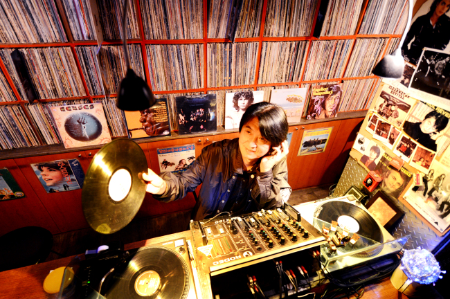 Kim Ik-ha, owner and DJ of Hongdae LP bar The Car with Two Tires, plays an LP record selected by a customer from his collection of thousands of records. Park Hyun-koo/The Korea Herald