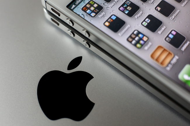 An Apple Inc. iPhone is arranged for a photograph next to the company’s logo in Seoul.   Bloomberg
