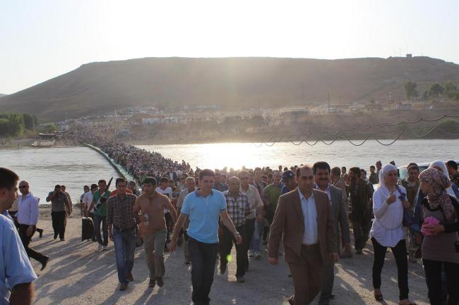 Syrian refugees walk from Syria into the Iraqi border town of Peshkhabour.   Xinhua-Yonhap News
