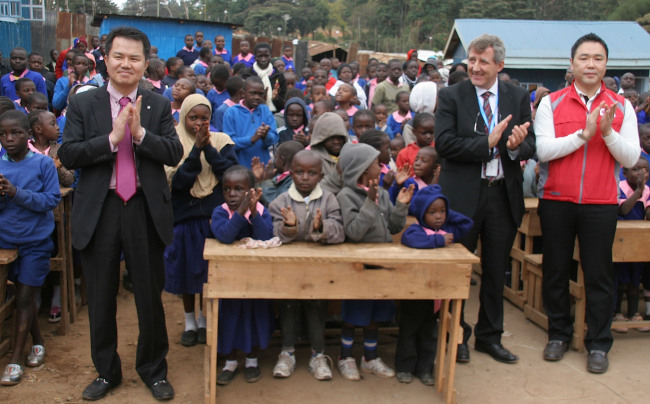 LG Electronics opened its LG Hope School in Kibera, Kenya, on Aug. 12. U.N. WFP’s Kenyan office vice head Paul Turnbull (second from right), LG Electronics’ Kenyan office vice head Kim Jung-jin (left) and LG’s CSR manager Kim Min-seok (right) celebrate with children.   LG Electronics