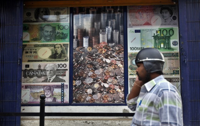 <YONHAP PHOTO-1726> An Indian talks on his mobile phone outside a currency exchange shop in Bangalore, India, Tuesday, Aug. 20, 2013. The rupee has plumbed new lows against the dollar on a near daily basis, showing the pressure of a current account deficit that has swelled from high import costs. A dollar now buys more than 63 rupees, a decline of 8 percent for the rupee so far this August. (AP Photo/Aijaz Rahi)/2013-08-20 23:05:17/ <저작권자 ⓒ 1980-2013 ㈜연합뉴스. 무단 전재 재배포 금지.>
A man on his mobile phone outside a currency exchange shop in Bangalore, India, Tuesday.    AP-Yonhap News