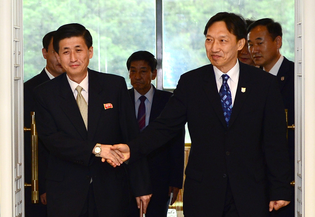 Lee Duck-hang (right), a senior official at the South Korean Red Cross, and Park Yong-il (left, front), a central committee
member of the North Korean Red Cross, and other officials arrive at the Peace House on the South side of
the border village of Panmunjeom on Friday for talks on reunions of separated families. (Unification Ministry)