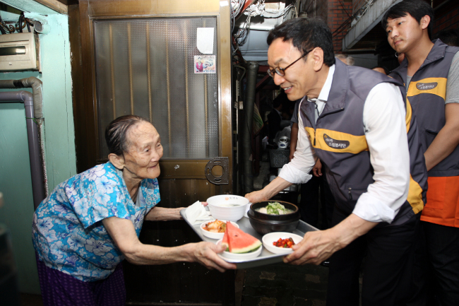 KB Kookmin Bank CEO Lee Kun-ho delivers “samgyetang,” a ginseng and chicken stew, to an elderly woman as part of its expanded social contribution program early this month.   KB Kookmin Bank