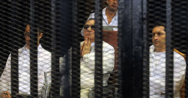 Former Egyptian President Hosni Mubarak (center) and his sons Gamal (left) and Alaa (right) are seen behind bars during their trial in Cairo on Sunday.   AFP-Yonahp News
