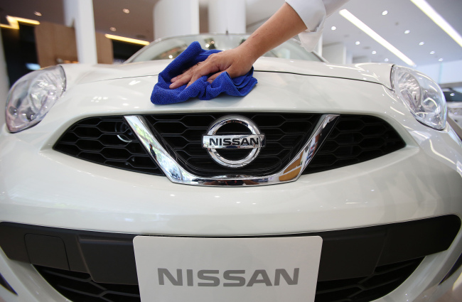 A salesperson cleans the front of a Nissan Motor Co. vehicle on display at the Siam Motor Sales dealership in Bangkok.   Bloomberg
