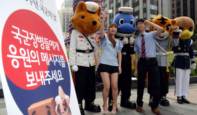 People pose with soldiers dressed as mascots of the different branches of the armed forces to promote Armed Forces Day, which falls on Oct. 1. South Korea’s military is celebrating its 65th anniversary this year.   Ahn Hoon/The Korea Herald
