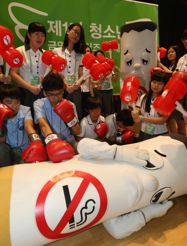 Students knock down a cigarette mascot at a ceremony to launch an anti-smoking campaign promoted by the Ministry of Health and Welfare on Aug. 5.   Yonhap News