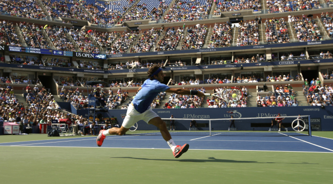 Roger Federer returns a shot to Carlos Berlocq during the second round of the 2013 U.S. Open tennis tournament in New York on Thursday.   AP-Yonhap News