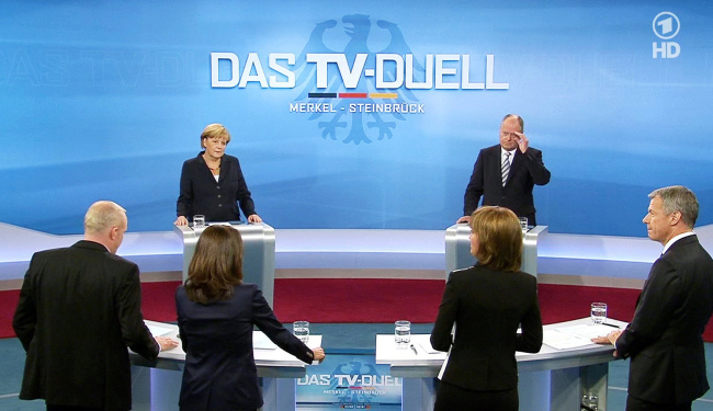 German Chancellor Angela Merkel (background left) of the Christian Democrats and her Social Democratic challenger Peer Steinbrueck (background right) with journalists during a live televised debate ahead of the national elections in Berlin on Sunday.   AP-Yonhap News