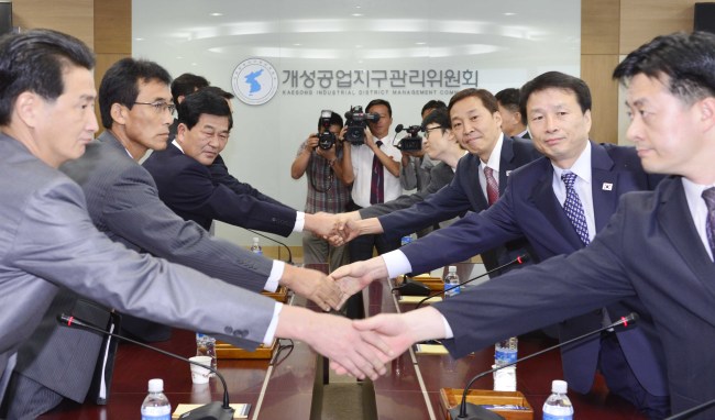 South Korea’s chief delegate Kim Ki-woong (right, third row) and his counterpart Park Chol-su shake hands during their talks in Gaeseong, North Korea, Monday.   Joint Press Corps