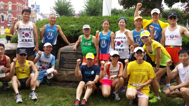 Participants in Bergen County’s first Comfort Women Memorial Peace Marathon pose around a memorial to the women near the starting line on Monday.   Yonhap News