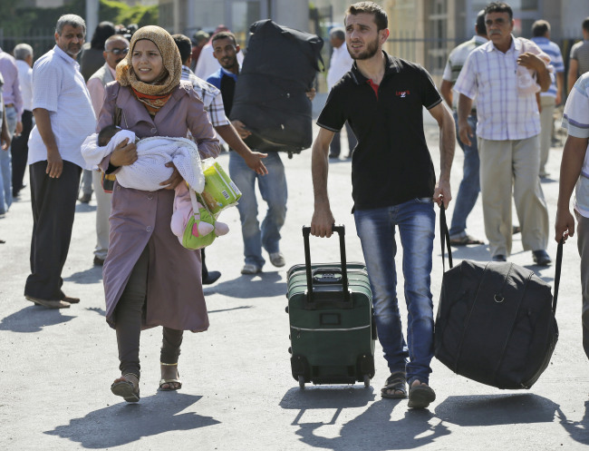 Syrian refugees pass through the Turkish Cilvegozu gate border on Sunday.   AP-Yonhap News