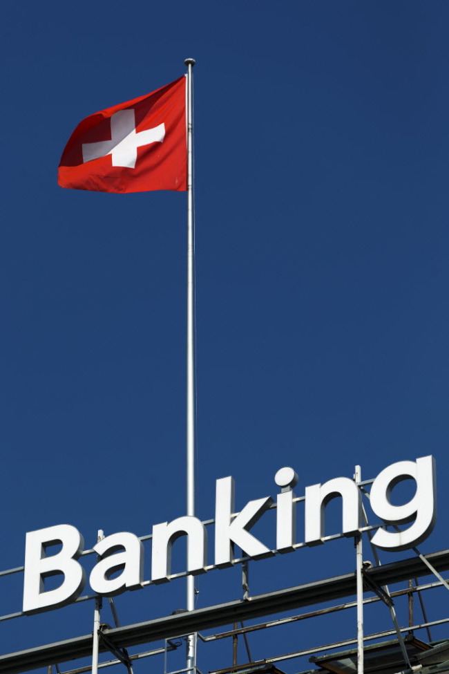 A Swiss national flag flies from the roof of the Bank Hapoalim Ltd. private banking offices in Geneva.      Bloomberg