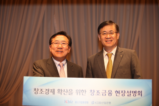 KDB Financial Group chairman Hong Ky-ttack (right) poses with Korea Federation of Small and Medium Business chairman Kim Ki-mun during a forum on the “creative finance” for SMEs in Seoul on Wednesday.   KDB