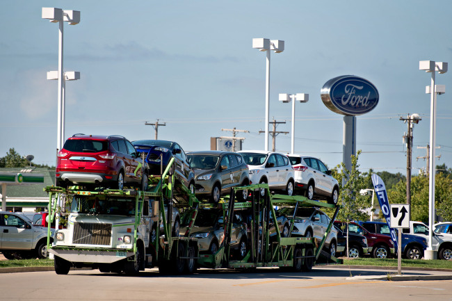 Ford Motor Co. Escape 2014 vehicles sit on a car carrier near the Bill Walsh Ford car dealership in Ottawa, Illinois.  Bloomberg