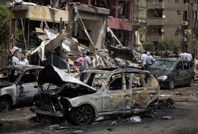 Egyptian security personnel investigate the scene of a bomb attack targeting the convoy of Egypt’s Interior Minister Mohammed Ibrahim, in Nasr City, Cairo, Thursday.   AP-Yonhap News
