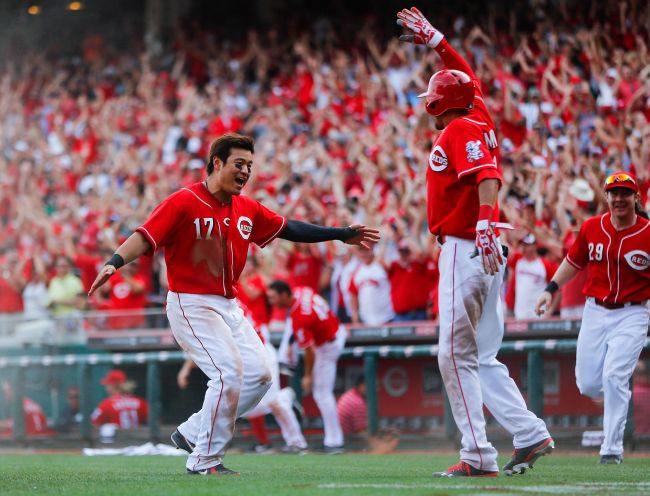 Reds outfielder Choo Shin-soo (left) runs to congratulate Billy Hamilton after he scored the winning run.   AFP-Yonhap News