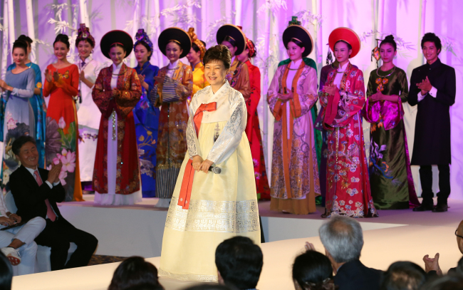President Park Geun-hye attends a fashion show featuring the traditional dresses of Korea and Vietnam -- the hanbok and the ao dai -- in the Vietnamese capital of Hanoi on Sunday. (Yonhap News)