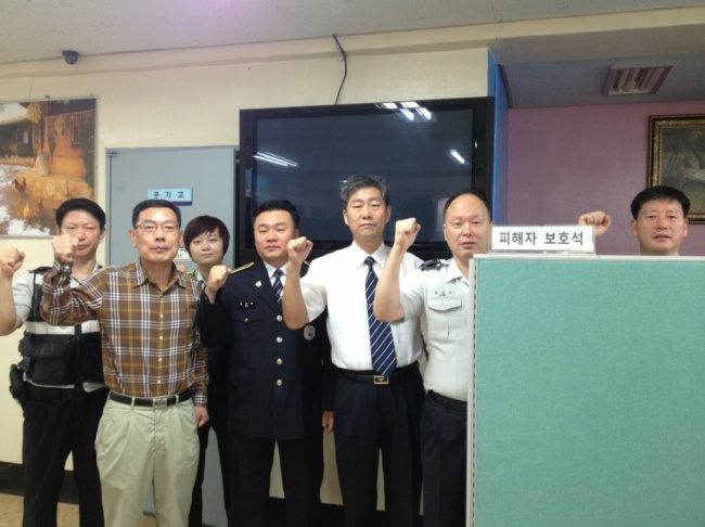 김희군(오른쪽에서 두 번째) 곰달래 지구대장이 전국 최초로 설치된 피해자석 옆에서 대원들과 함께 파이팅을 외치고 있다.