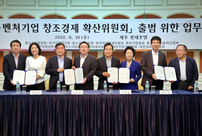 Kim Ki-moon (fourth from left), chairman of the Korea Federation of Small and Medium Business, and representatives of venture firms and smaller companies pose to celebrate the launch of a committee supporting creative economy policies at a Jeju hotel on June 19.   Korea Federation of Small and Medium Business