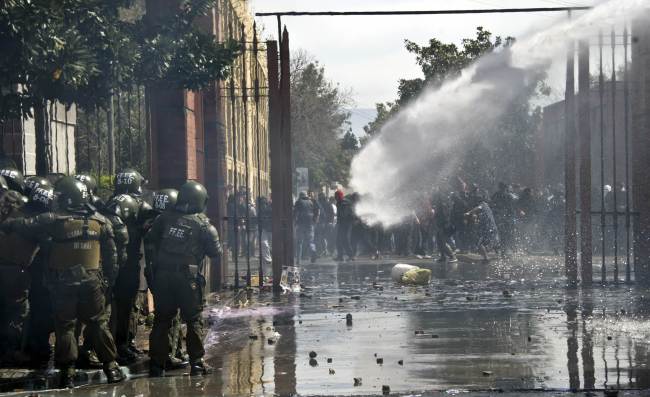 Protesters clash with police as activists of the Chilean human rights organization Detained and Disappeared People take part in a demonstration in Santiago on Sunday.   AFP-Yonhap News